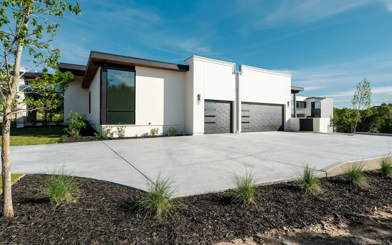 Modern white home with two dark sectional garage doors