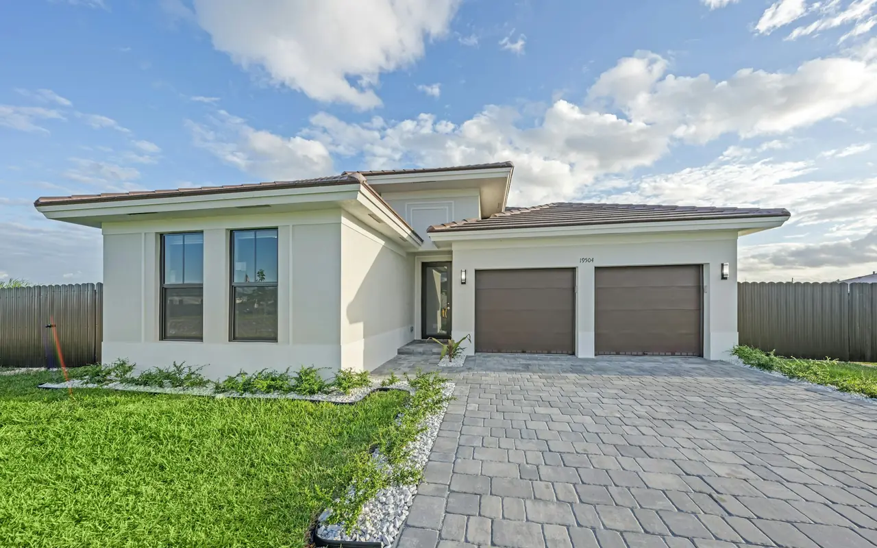 Single-story home with two sectional garage doors and a paved driveway