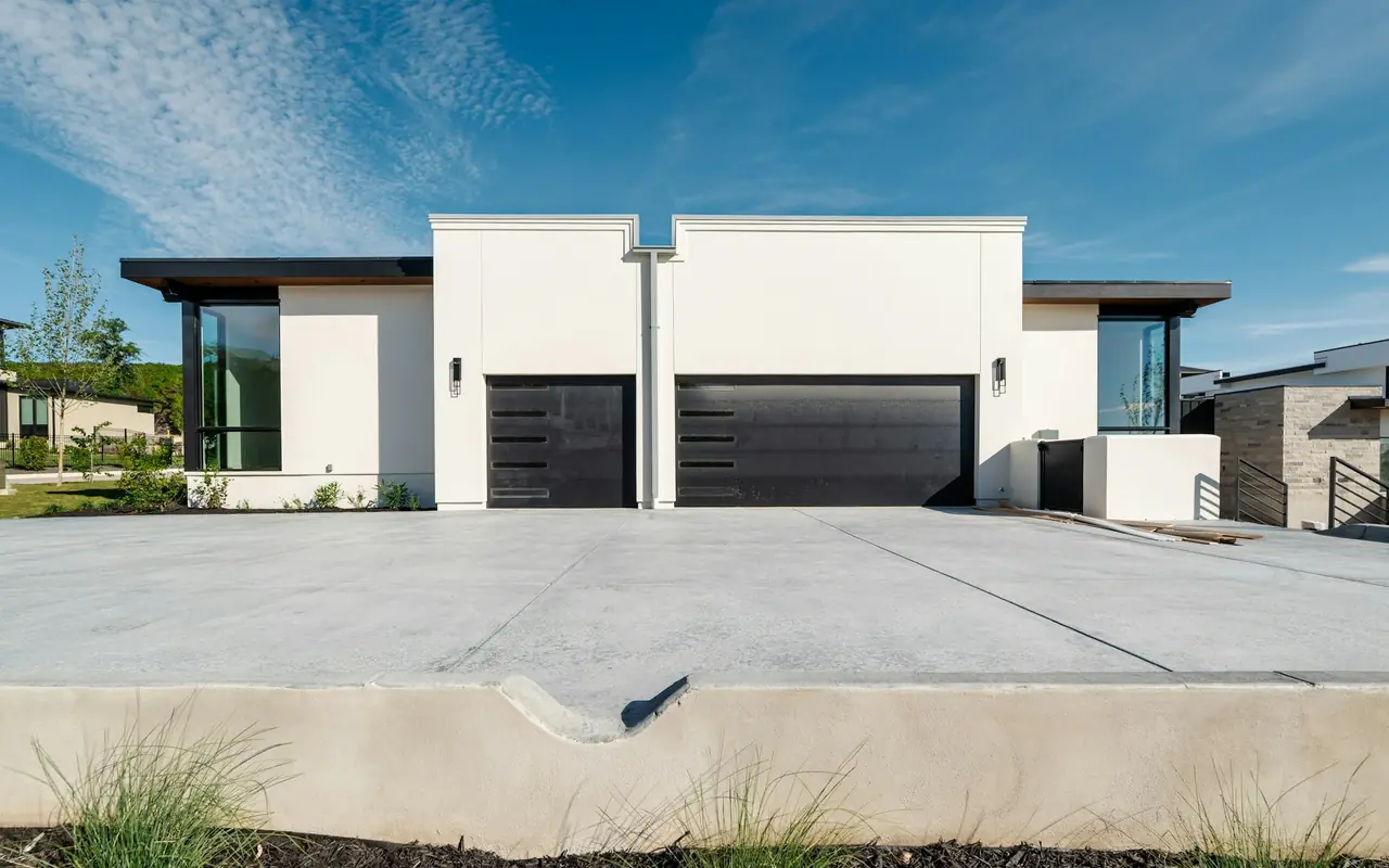 Contemporary white homes with black sectional garage doors